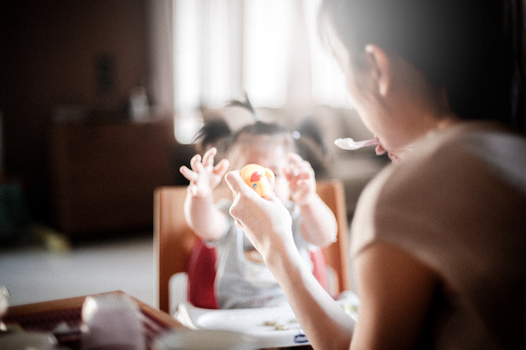 mãe a brincar e a alimentar a sua filha bebé de forma desacelerada.